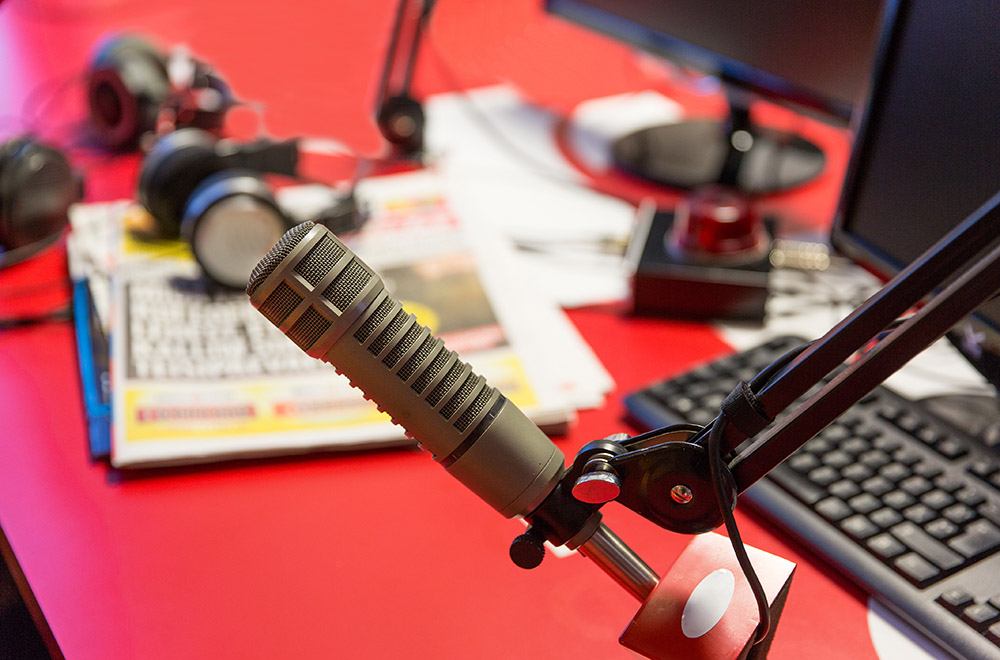 technology, electronics and audio equipment concept - close up of microphone at recording studio or radio station